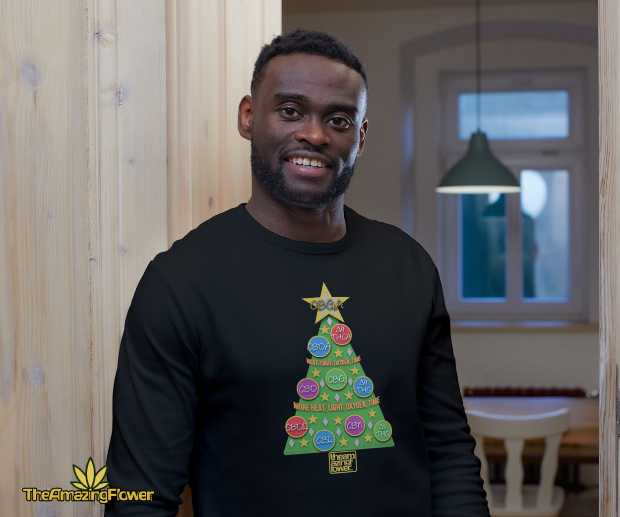 Cannabinoid Holiday Tree Long Sleeve Black T-shirt worn by a smiling man in the doorway to his kitchen